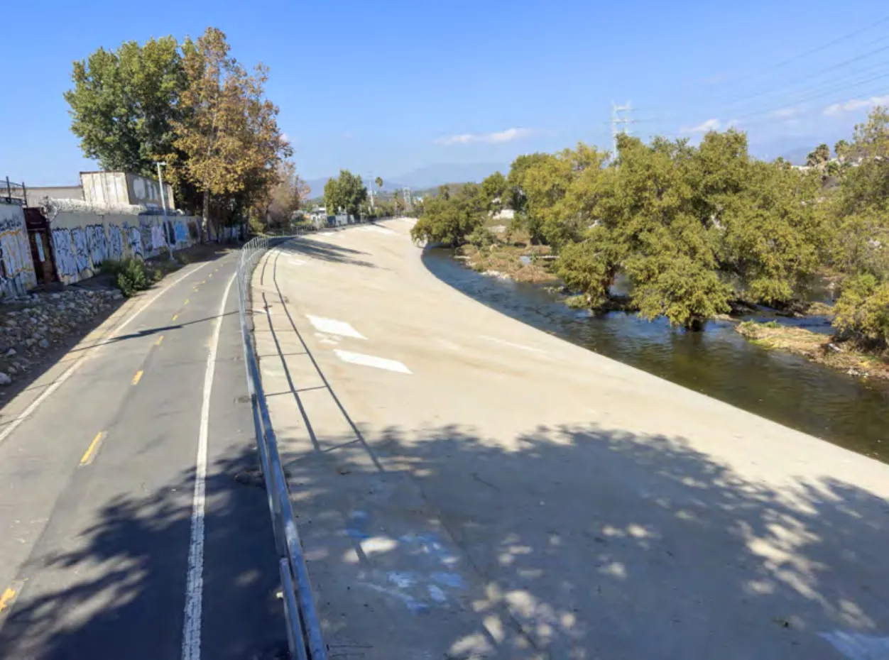 The LA River bike path curving alongside the river and trees