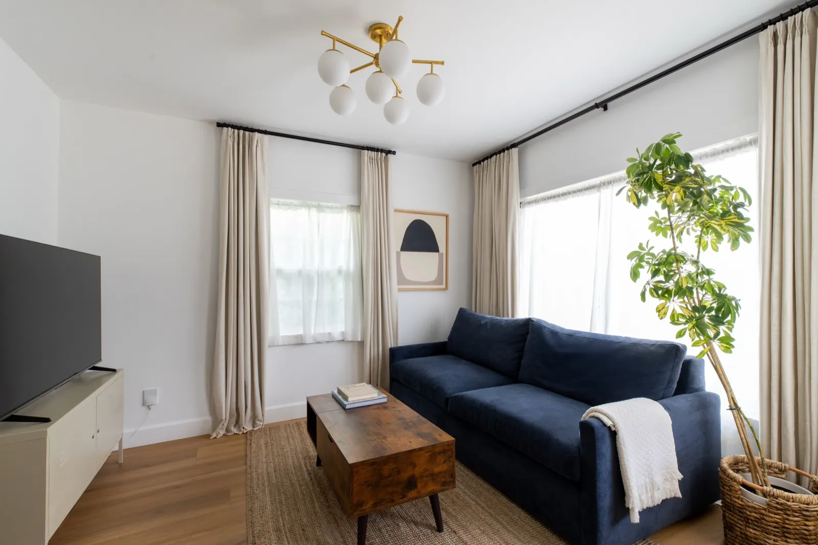 Living room with navy sofa and brass fixtures
